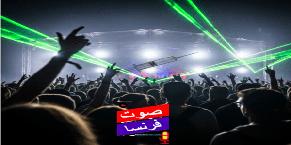 صورة لحشد في مهرجان موسيقي مع أضواء ليزر خضراء وسوداء، وتظهر إبرة كبيرة محلقة فوق الرؤوس، ترمز لظاهرة "الطعن بالإبر".